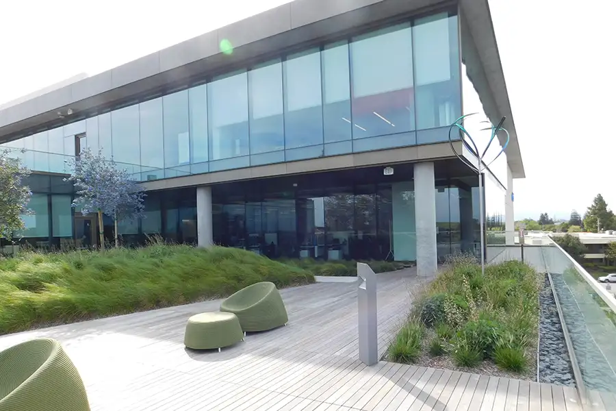 Exterior of glass clad office building with tall grasses incorporated into the landscaping.