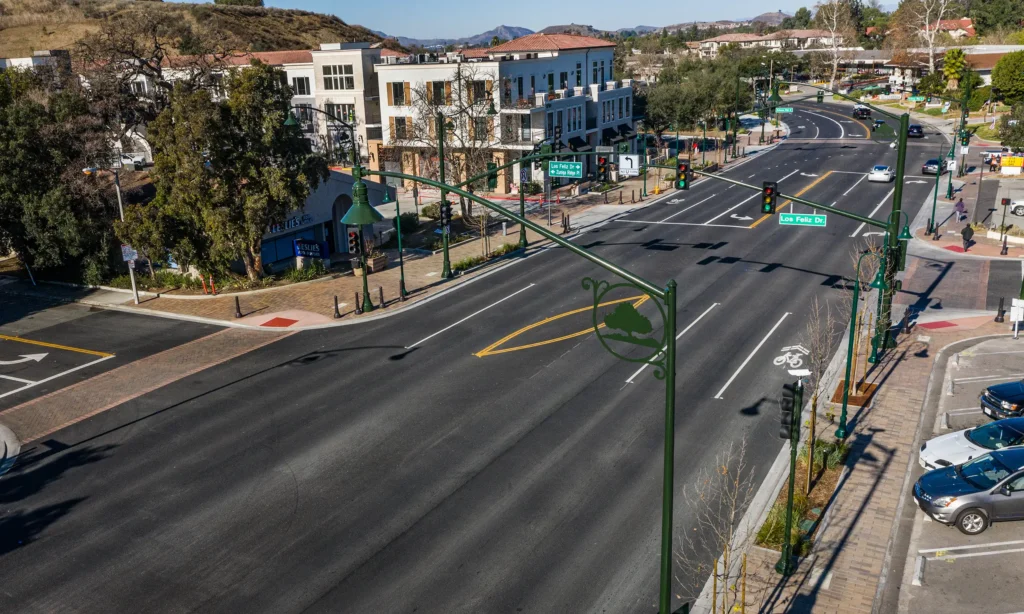 Newly paved six lane road with mixed-use building and businesses along the road.