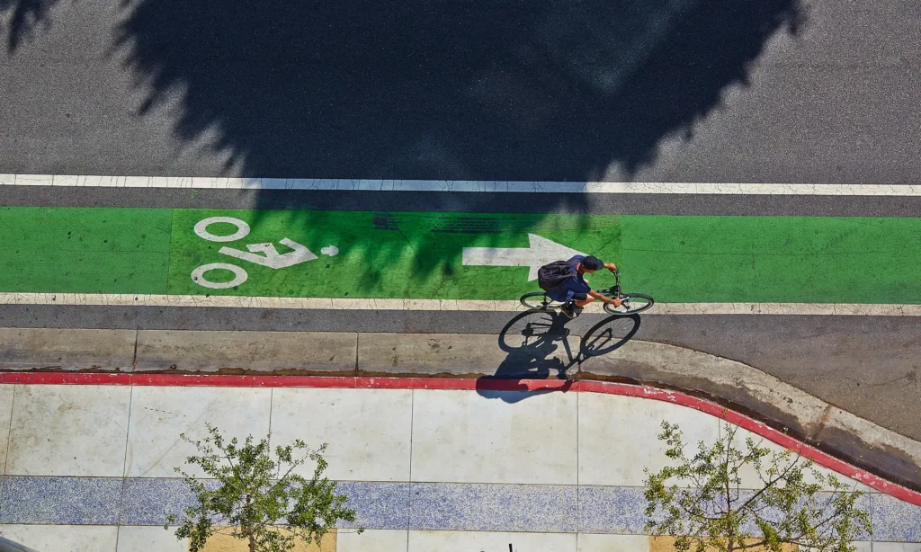 Aerial top-down view of person riding a bike in a bike lane painted green.