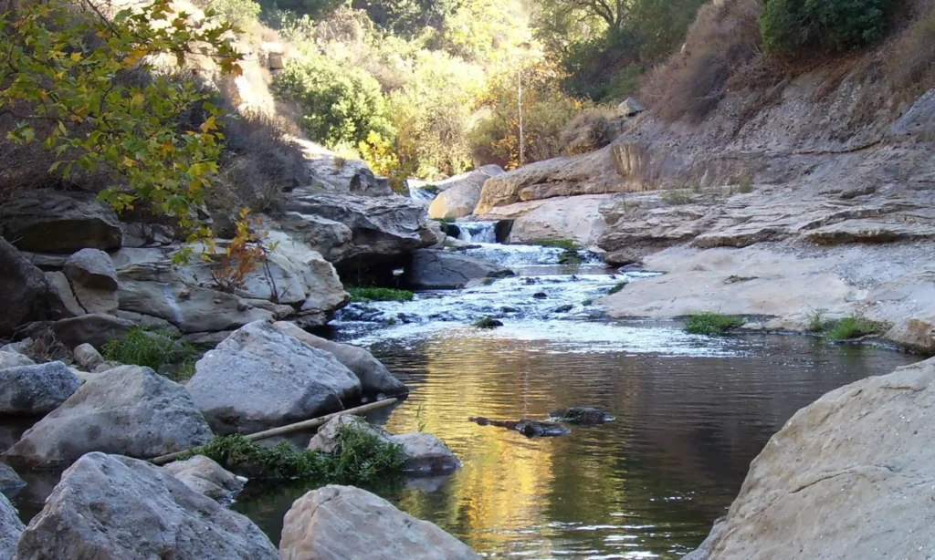 Water cascading down a rocky creek finishing at a small pond in the wilderness.